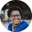 Nuria con gafas sonriendo mientras mira hacia la derecha en su foto de testimonio