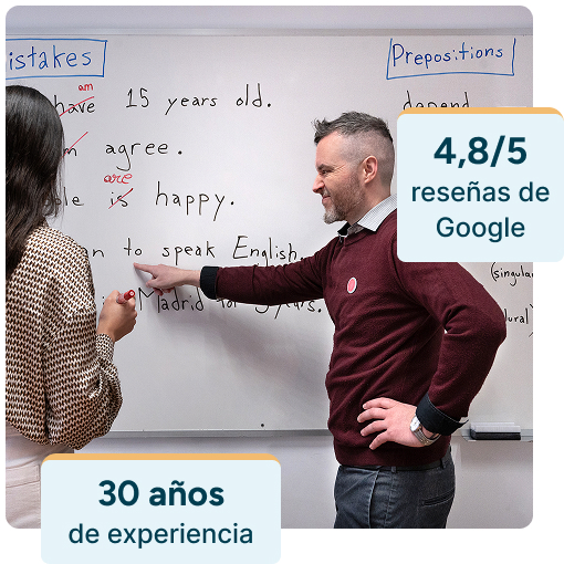 Fotografía de uno de nuestros profesores nativos titulados explicando a una alumna con la pizarra. La alumna está participando. Sobre la foto, unos gráficos indican que tenemos 4.8/5 estrellas en Google y 30 años de experiencia desde que la academia Seif se fundó en 1993.